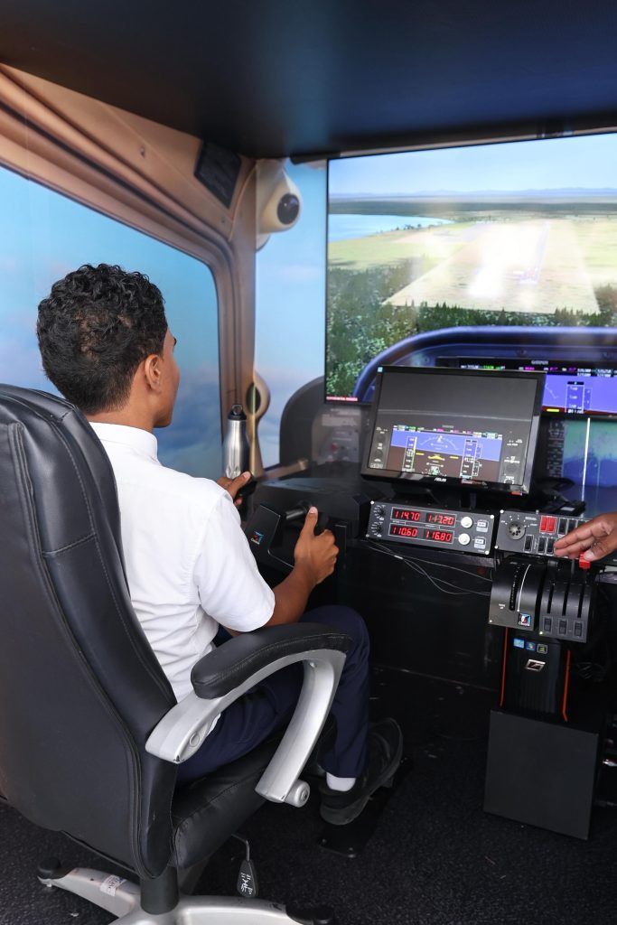Estudiante vive la experiencia del Simulador de Vuelo en el stand del IDAC en la Feria Regional del Libro y la Cultura.